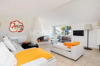 a living room with white furniture and a fireplace at Votre maison de vacances dans un écrin de verdure - Cannes in Cannes
