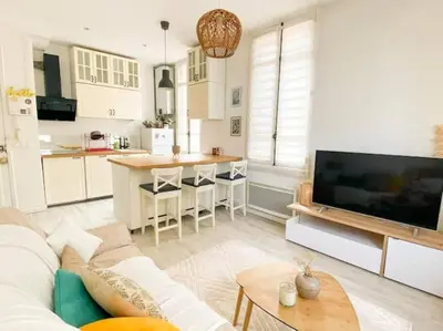 a living room with a couch and a kitchen at Joli appartement au calme à 10 min à pied des Marches et des plages in Cannes