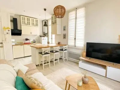 a living room with a couch and a kitchen at Joli appartement au calme à 10 min à pied des Marches et des plages in Cannes
