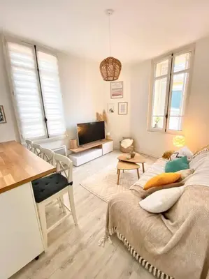 a living room with a bed and a flat screen tv at Joli appartement au calme à 10 min à pied des Marches et des plages in Cannes