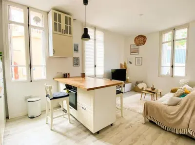 a kitchen and living room with a desk and a couch at Joli appartement au calme à 10 min à pied des Marches et des plages in Cannes