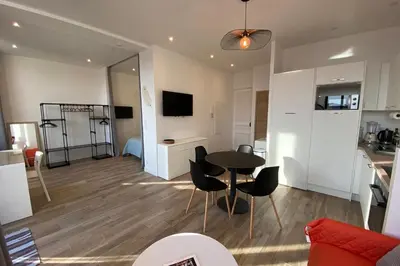 a kitchen and a living room with a table and chairs at 06CJ Beautiful apartment in the heart of Cannes in Cannes