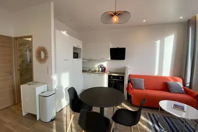 a living room with a red couch and a table at 06CJ Beautiful apartment in the heart of Cannes in Cannes