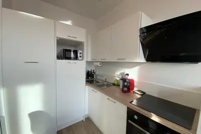 a kitchen with white cabinets and a counter top at 06CJ Beautiful apartment in the heart of Cannes in Cannes