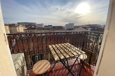 a balcony with a bench and a view of a city at 06CJ Beautiful apartment in the heart of Cannes in Cannes