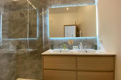 a bathroom with a sink and a shower with a mirror at 06CJ Beautiful apartment in the heart of Cannes in Cannes