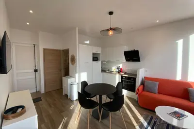 a living room with a red couch and a table at 06CJ Beautiful apartment in the heart of Cannes in Cannes