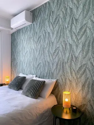 a bedroom with a bed and a wall with a leaf pattern at L'Hippocampe - Studio - Croisette - Proche Palais in Cannes