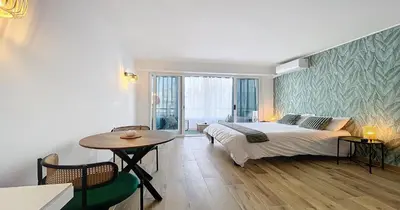 a bedroom with a bed and a table and a window at L'Hippocampe - Studio - Croisette - Proche Palais in Cannes