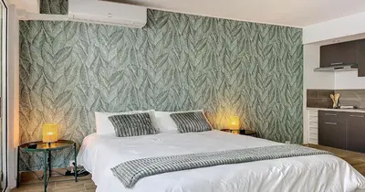 a bedroom with a bed and a green wall at L'Hippocampe - Studio - Croisette - Proche Palais in Cannes