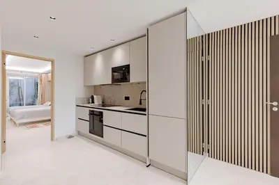 a kitchen with white walls and sliding glass doors at Cannes apartment sea view - 18H in Cannes