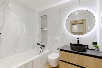 a white bathroom with a sink and a mirror at Cannes apartment sea view - 18H in Cannes