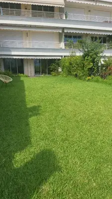 a large yard of green grass in front of a building at Cannes apartment sea view - 18H in Cannes