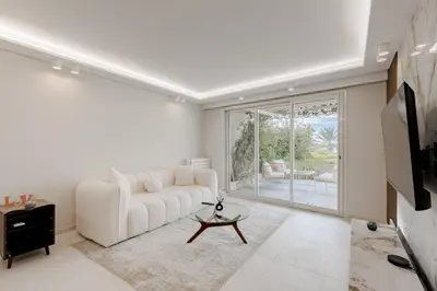 a living room with a white couch and a tv at Cannes apartment sea view - 18H in Cannes