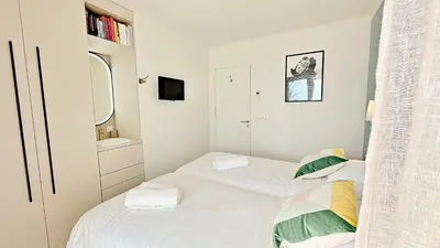a small bedroom with two beds and a mirror at Une véritable perle 342L HUI in Cannes