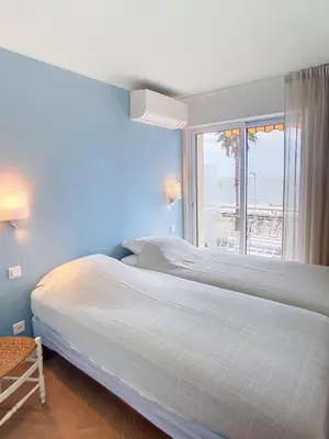 two beds in a bedroom with a view of the ocean at Une véritable perle 342L HUI in Cannes