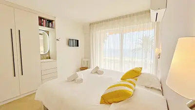 a white bedroom with a bed with yellow pillows at Une véritable perle 342L HUI in Cannes