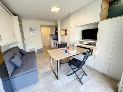 a small living room with a table and a couch at Superbe studio, piscine 330L Giov in Cannes