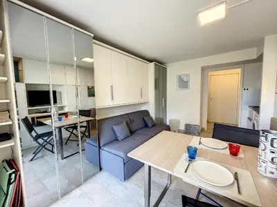 a living room with a couch and a table at Superbe studio, piscine 330L Giov in Cannes
