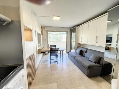 a living room with a couch and a table at Superbe studio, piscine 330L Giov in Cannes