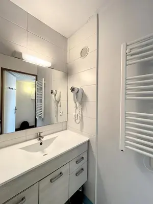 a white bathroom with a sink and a mirror at A deux pas des plages du Midi 308L Mour in Cannes