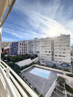 a large building with a swimming pool in front of it at A deux pas des plages du Midi 308L Mour in Cannes