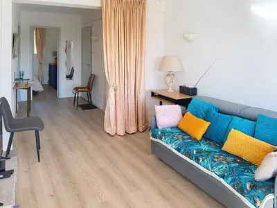 a living room with a blue couch with colorful pillows at Superbe 2 pièces 344L Jol in Cannes