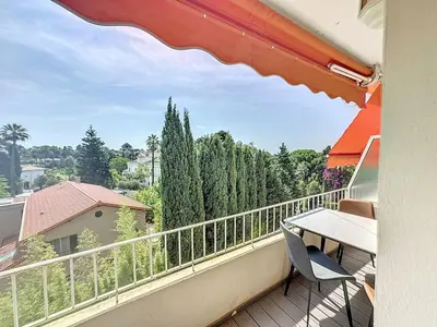 a balcony with a table and a view of trees at Superbe 2 pièces 344L Jol in Cannes