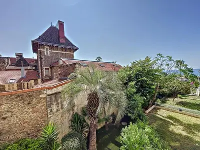an old house with a palm tree in front of it at A 2 pas des plages du Midi, 261L DEPER in Cannes
