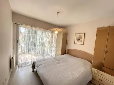 a bedroom with a bed and a large window at A 2 pas des plages du Midi, 261L DEPER in Cannes
