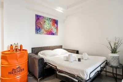 a bedroom with a bed and a colorful painting on the wall at Modern 1 bedrm apt with balcony - Cannes-Croisette in Cannes