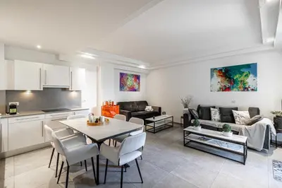 a kitchen and a living room with a table and chairs at Modern 1 bedrm apt with balcony - Cannes-Croisette in Cannes