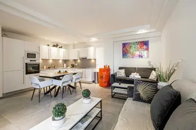 a living room and kitchen with a couch and a table at Modern 1 bedrm apt with balcony - Cannes-Croisette in Cannes
