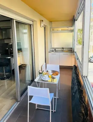 a balcony with a table and chairs and a kitchen at Studio premium St Louis - emplacement idéal in Cannes