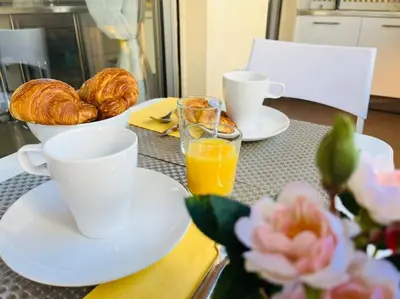 a table with cups and a bowl of croissants and orange juice at Studio premium St Louis - emplacement idéal in Cannes