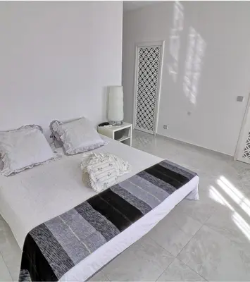 a white bedroom with a large bed and a lamp at Appartement Haut Standing 5 pièces Cannes centre in Cannes