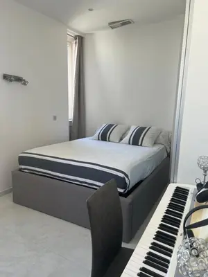 a bed in a bedroom next to a piano at Appartement Haut Standing 5 pièces Cannes centre in Cannes
