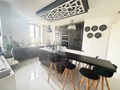 a kitchen with a black counter and bar stools at Appartement Haut Standing 5 pièces Cannes centre in Cannes