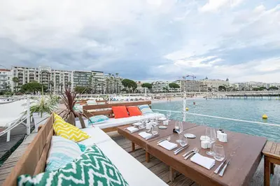 a patio with tables and chairs next to a pool at Emplacement idéal 450 métres du Palais croisette plage in Cannes