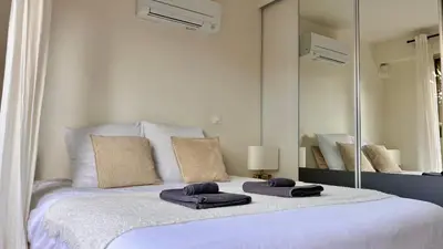 a bedroom with a large bed with two towels on it at L'Azur - Apt de Standing - Piscine - Parking in Le Cannet