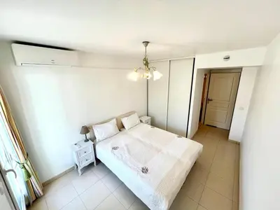 a white bedroom with a bed and a table at Spacieux 2 chambres TERRASSE, PARKING proche CENTRE VILLE A2B237 in Cannes