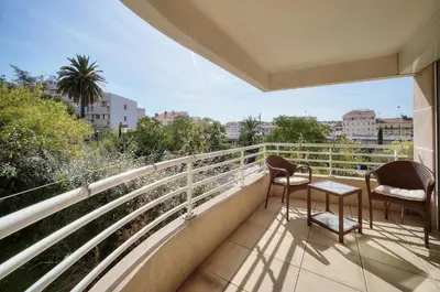 a balcony with two chairs and a view of a city at Spacieux 2 chambres TERRASSE, PARKING proche CENTRE VILLE A2B237 in Cannes
