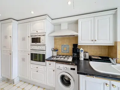 a white kitchen with a sink and a dishwasher at Intuition - 2 personnes - Le Fragonard in Cannes