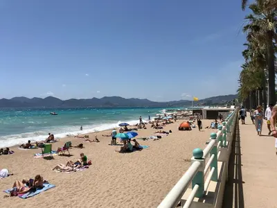 a group of people on a beach near the ocean at T2 Vallombrosa Terrasse Parking in Cannes