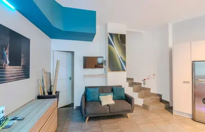a living room with a couch and stairs at Maison 4 chambres - Cannes centre -Clim WIFI 7 personnes in Cannes