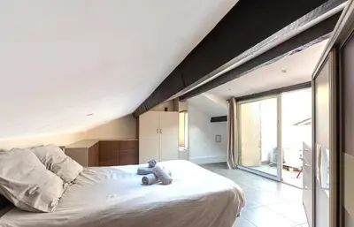 a teddy bear sitting on a bed in a bedroom at Maison 4 chambres - Cannes centre -Clim WIFI 7 personnes in Cannes
