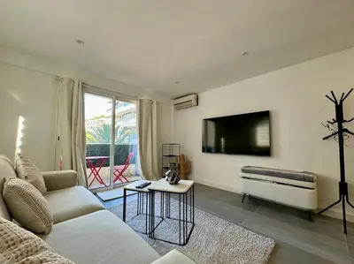 a living room with a couch and a flat screen tv at Studio de 30m2 - À 5min du centre in Cannes
