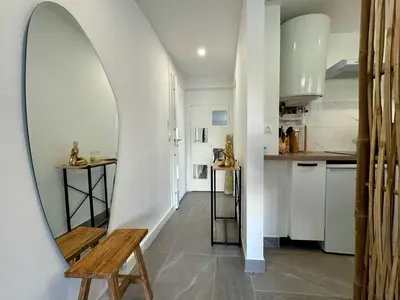 a hallway with a mirror and a wooden bench at Studio de 30m2 - À 5min du centre in Cannes
