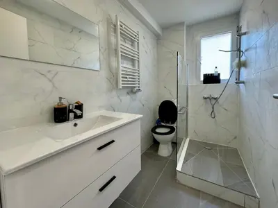 a white bathroom with a sink and a toilet at Studio de 30m2 - À 5min du centre in Cannes