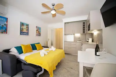 a living room with a bed and a kitchen at Le Studio Cannois Standing Presta in Cannes